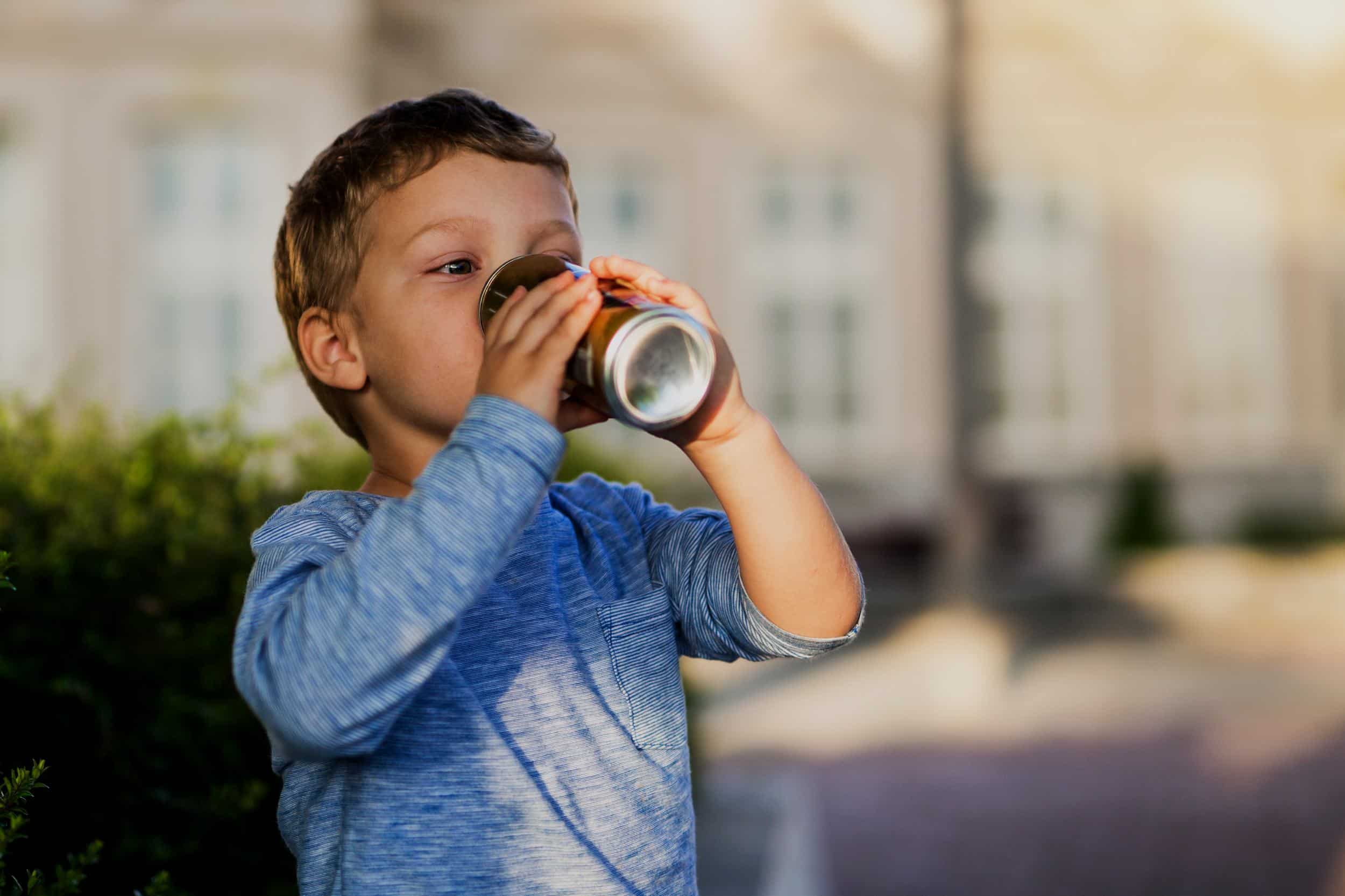 enfant boit une boisson sucree